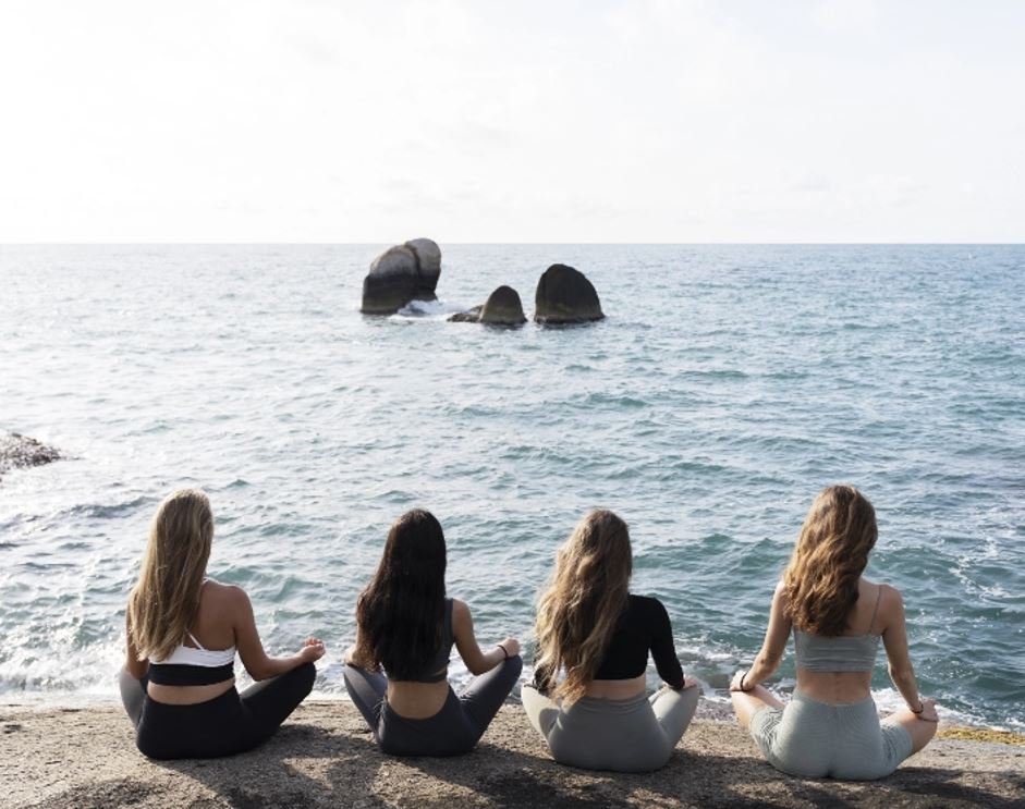 full-shot-women-meditating-by-sea
